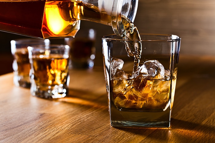What is the Difference Between Bourbon and Whiskey - pouring into glass