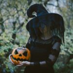 Halloween Puns - witch holding a jack-o'-lantern