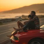 Questions to Ask a Guy - man and woman sitting on car at sunset