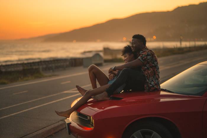 Questions to Ask a Guy - man and woman sitting on car at sunset