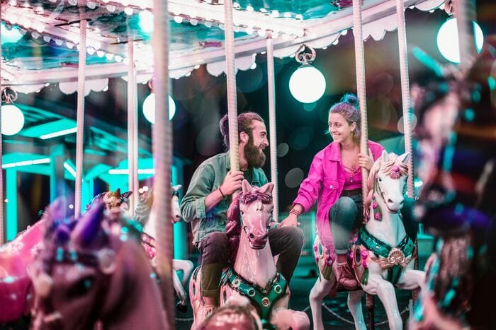 what to ask before you move in together - couple riding a carousel