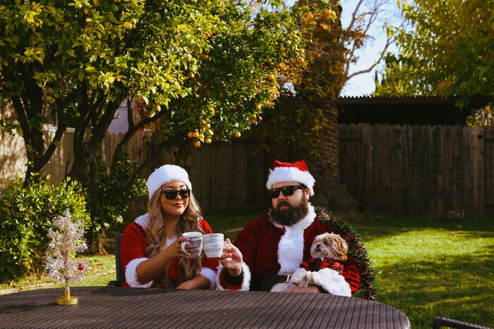 what to ask before you move in together - couple in Santa costumes with a dog