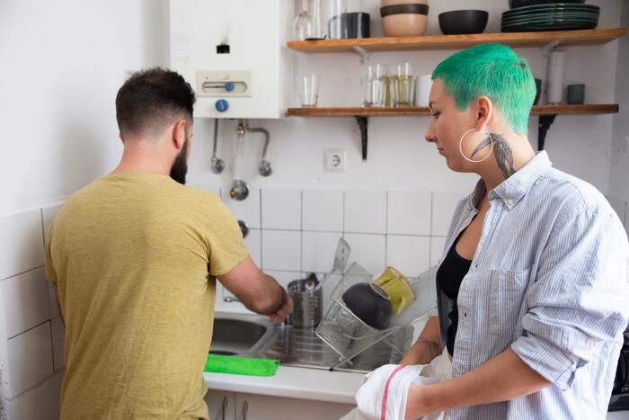 what to ask before you move in together - couple washing dishes